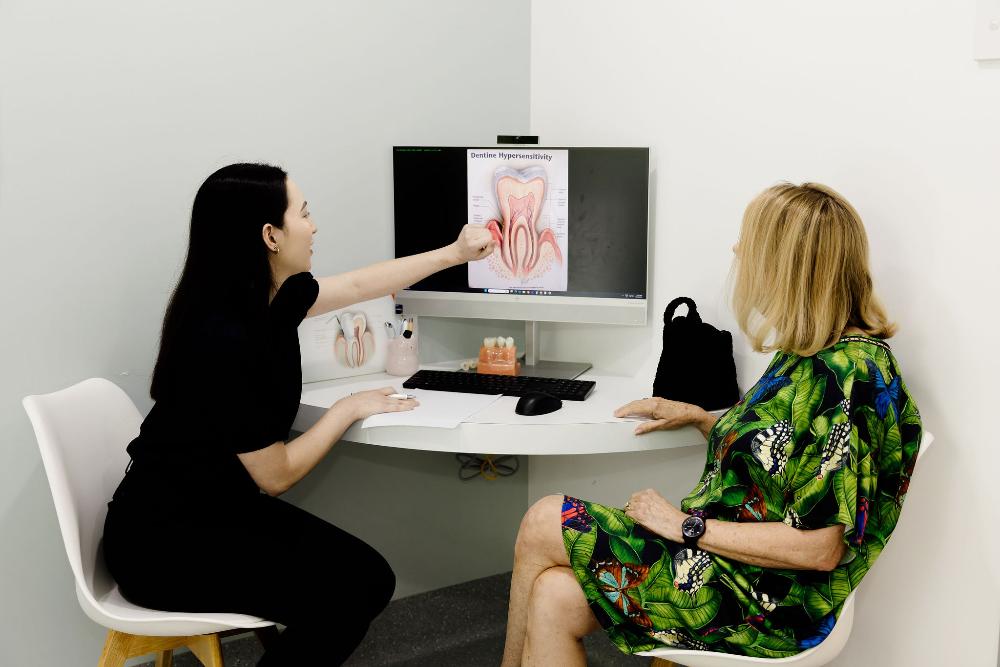 A woman and her colleague are at a desk, focusing on general dentistry topics in Clayfield.