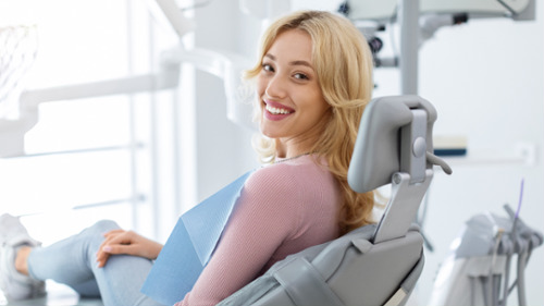 Smiling young woman relaxing in dental chair during a dental appointment at a modern practice