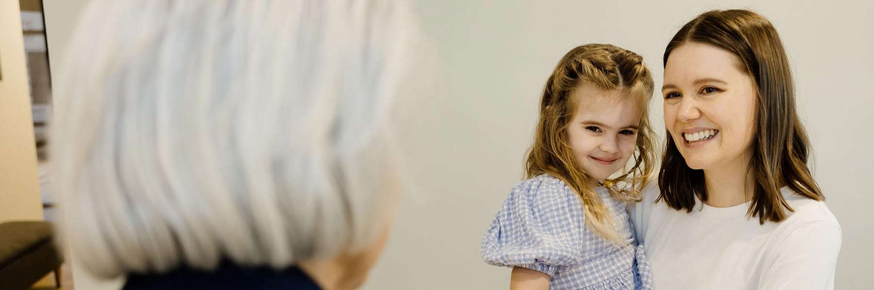 A woman and children share smiles, highlighting a warm moment at Children's Dentistry in Clayfield.