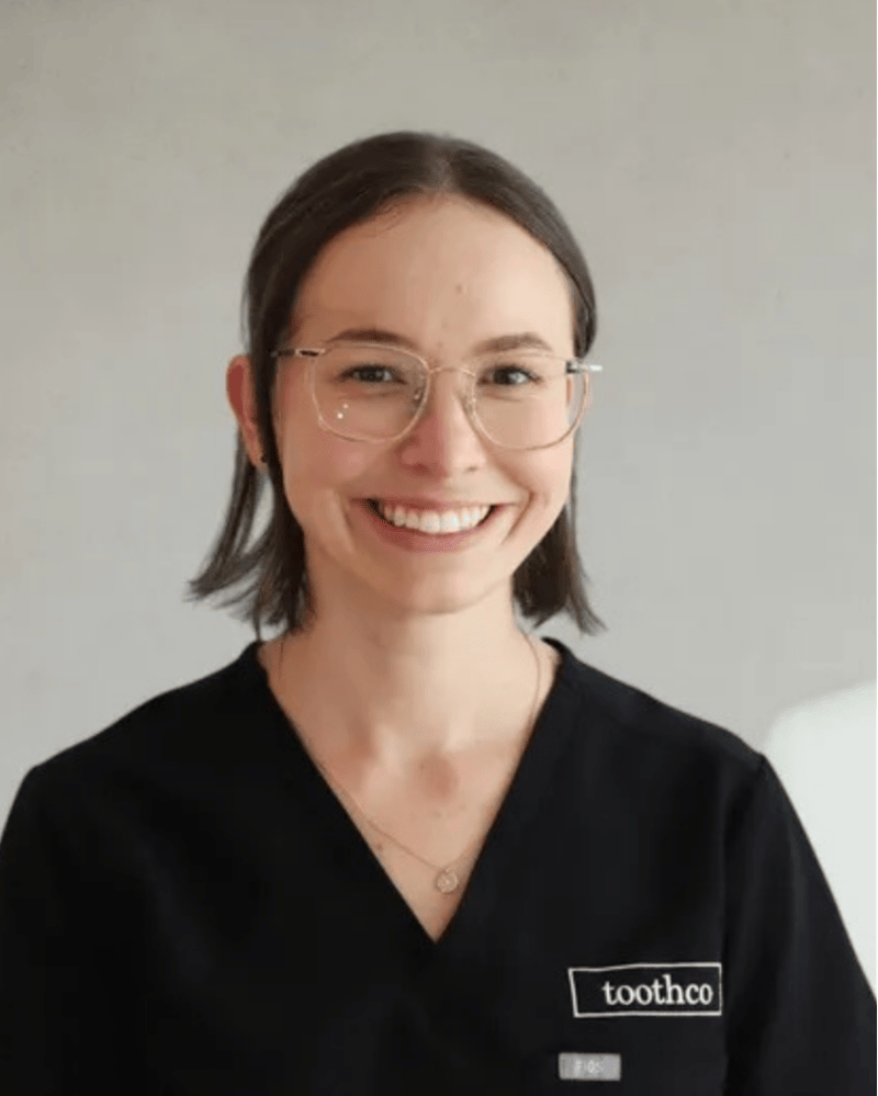 Dr Ebony Watson, cosmetic dentist at Northside Dental Solutions, smiling warmly in black dental scrubs
